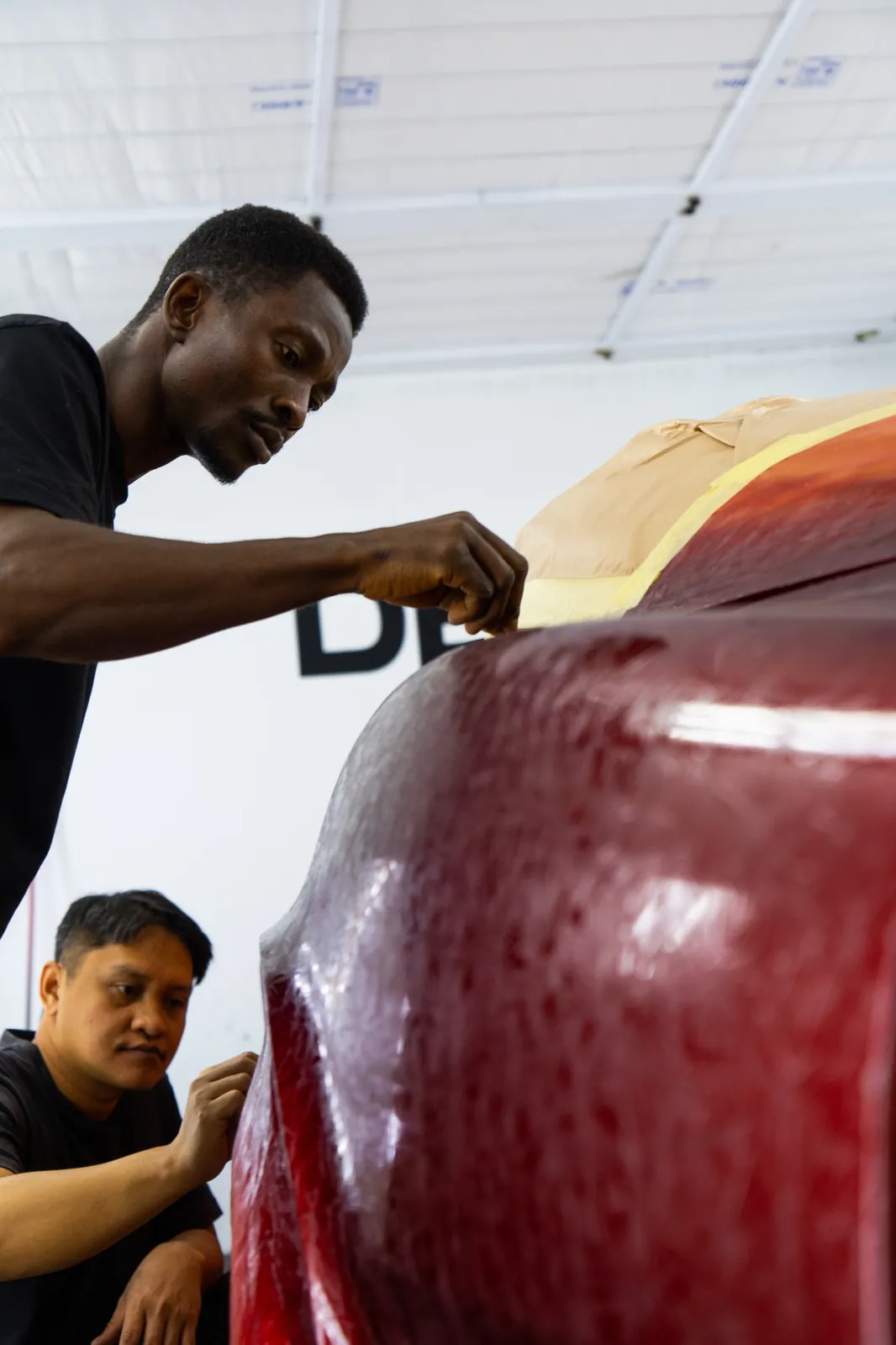 DEIZ Garage technicians preparing and masking a vehicle before repainting